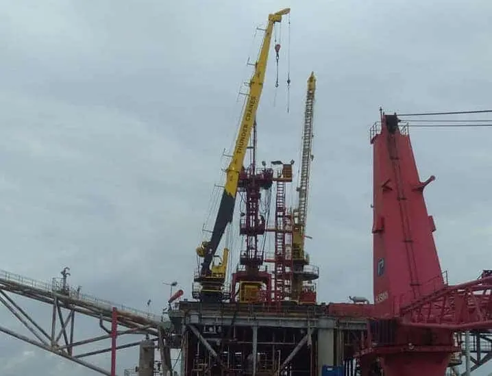 Thunder Crane HWO offshore support operations with yellow lifting equipment on industrial ocean platform