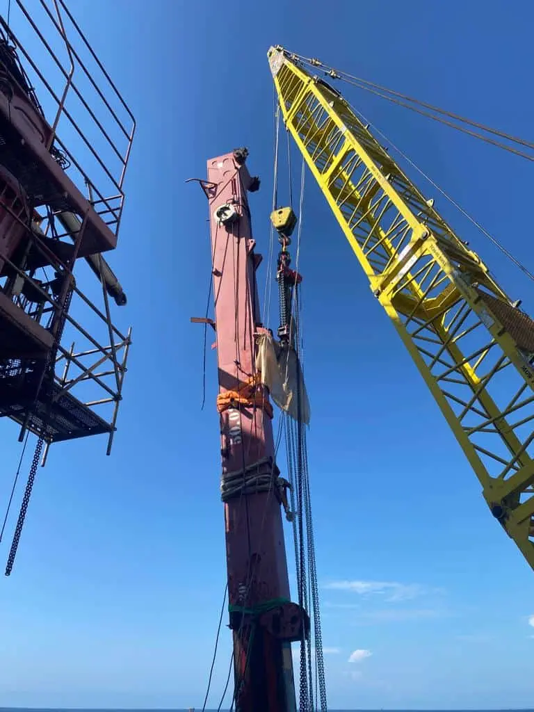 Offshore Angola platform with Thunder Crane yellow lifting equipment handling red industrial machinery